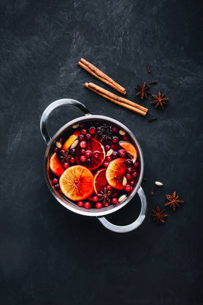 Mulled Wine Hot Drink with Cranberries, oranges, apples and spices on dark concrete background. Mulled Wine Hot Drink with Cranberries, oranges, apples and spices on dark concrete background. Top view, copy space mulled wine photos stock pictures, royalty-free photos & images