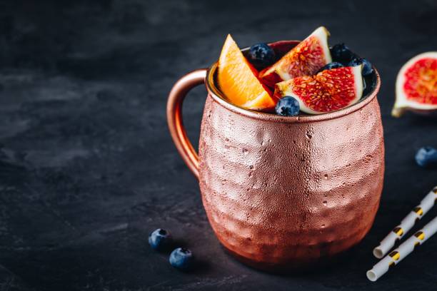 istock Fig moscow mule ice cold cocktail in copper cup with blueberries and orange 1183547066