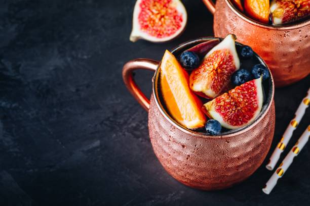 istock Fig moscow mule ice cold cocktail in copper cup with blueberries and orange 1183547082