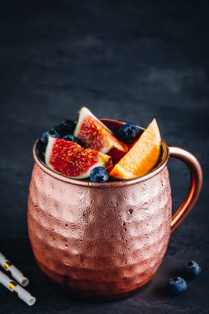 istock Fig moscow mule ice cold cocktail in copper cup with blueberries and orange 1183547089