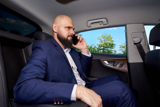 istock Successful young man talking on the phone in a car. 1183549027