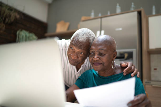 pareja senior haciendo finanzas en el hogar - home finances couple computer african ethnicity fotografías e imágenes de stock