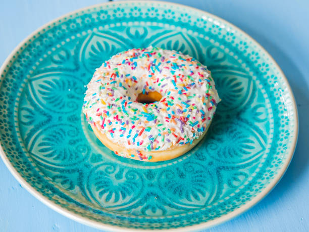 istock Delicious sprinkled white sweet donut - top view 1183551423