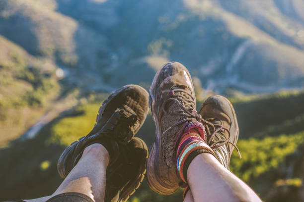 istock Two women´s feet wearing sneakers on mountain peak 1183556468
