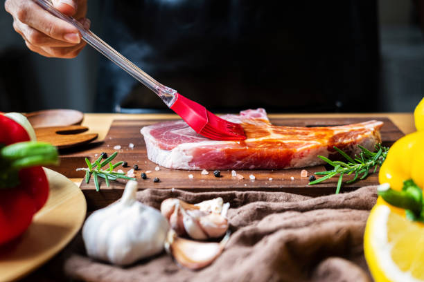 chef prepara chuleta de cerdo con salsa barbacoa en la cocina - marinated fotografías e imágenes de stock