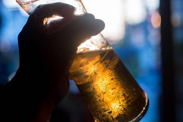 beer cold in glass on hand and sunlight in evening