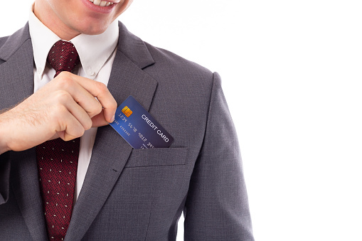 Businessman pick credit card from suit pocket for paying, buying, shopping product with smiley face, happiness. Handsome young businessman get convenient, comfortable, relaxed. Working guy.