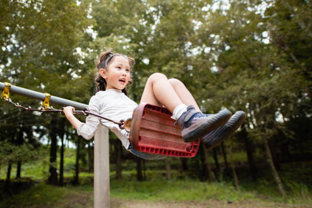 istock Cute girl playing on a swing 1183563113