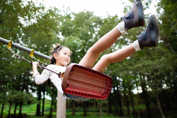 istock Cute girl playing on a swing 1183563118