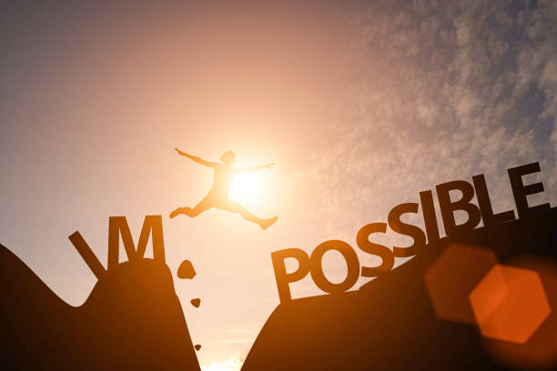 Man jump between impossible wording and possible wording on mountain. Mindset for career growth business. Man jump between impossible wording and possible wording on mountain. Mindset for career growth business. impossible possible stock pictures, royalty-free photos & images