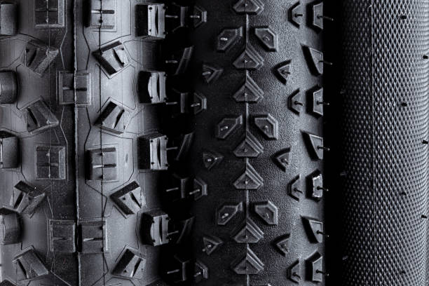 macro close-up de piso de vários pneus de bicicleta de borracha preta com diferentes tipos de perfil isolado fundo branco - mountain cycling bicycle tire - fotografias e filmes do acervo