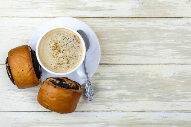 istock Composition with a Cup of coffee and buns on the white wooden kitchen table 1183565037