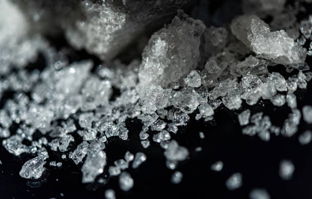 istock Large crystal of salt on black reflective surface; selective focus; natural edible salt 1183566183