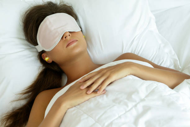 istock Woman is wearing eye mask and using earplugs 1183568737