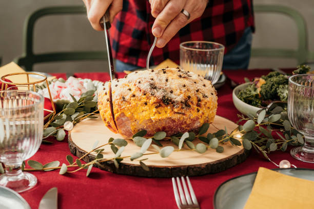 istock Man cutting christmas ham 1183571600