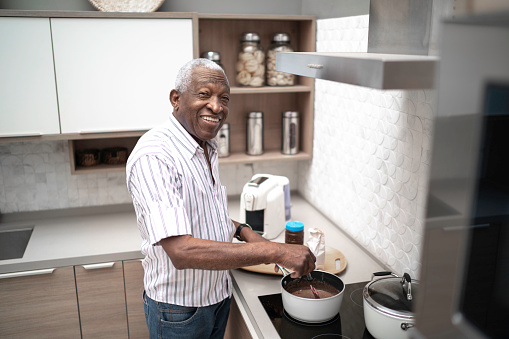 Portrait of a senior man cooking brigadeiro