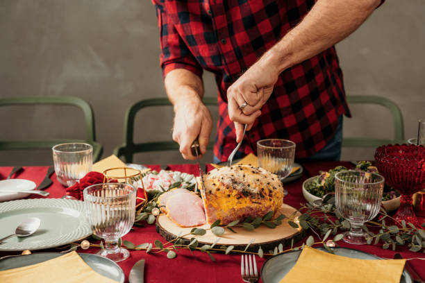 istock Man cutting christmas ham 1183571760