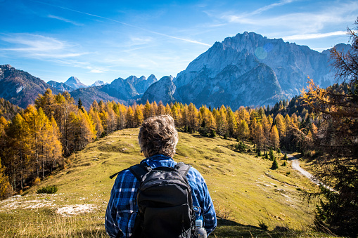 Senior man looking at beautiful autumn mountain view in Italian Alps