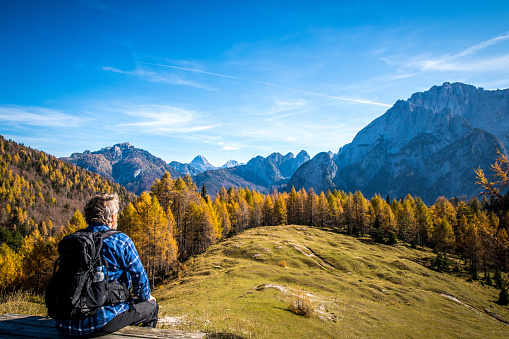 Senior man looking at beautiful autumn mountain view in Italian Alps, Sella Somdogna Plateau
