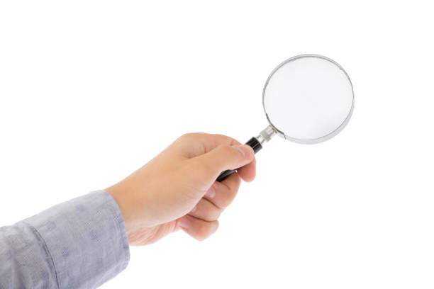 istock Hand holds magnifying glass isolated on white background 1183574249