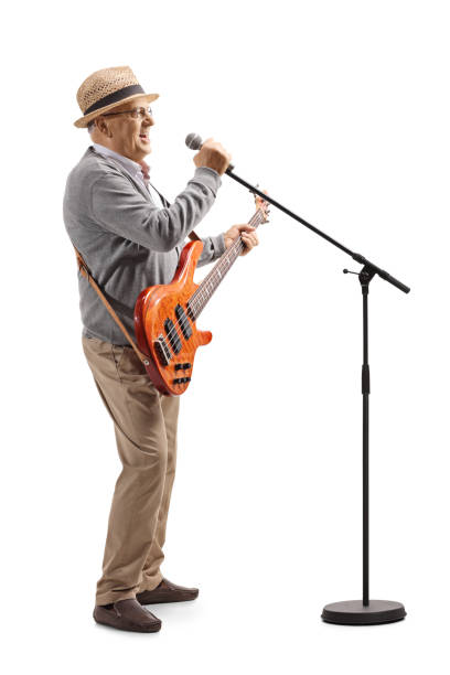 istock Senior man with a bass guitar singing on a microphone 1183576411