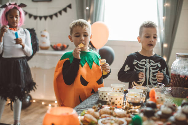 dzieci jedzące na halloweenowym przyjęciu - house halloween autumn candid zdjęcia i obrazy z banku zdjęć