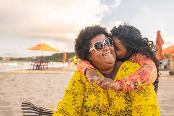 niña besando a su madre y disfrutando de la playa - child men family embracing fotografías e imágenes de stock