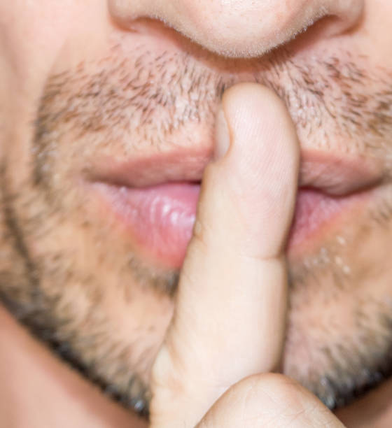 istock Macro of man touching lips with finger 1183579342