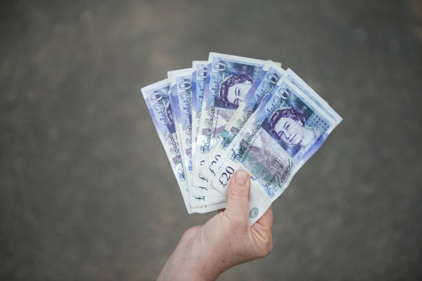 英国通貨ポンド紙幣の認識できない高齢者保持グループの高角度ビュー - british currency currency human hand paper currency ストックフォトと画像