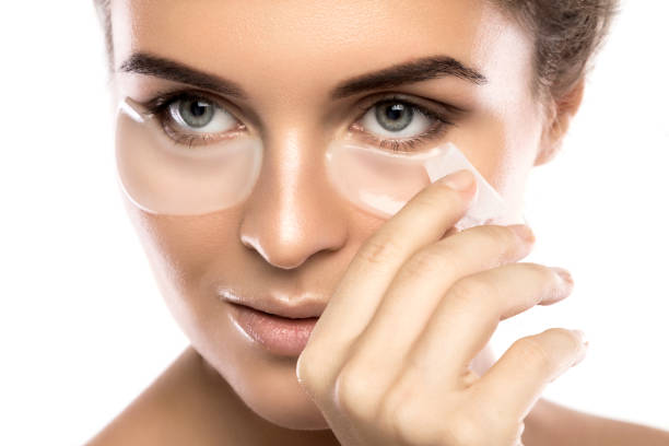 istock Woman with collagen pads under her eyes 1183585196