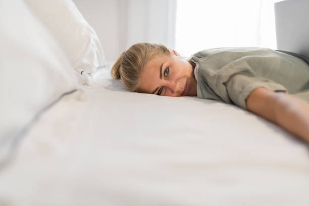 istock Blond woman lying down smiling looking towards the camera 1183585630