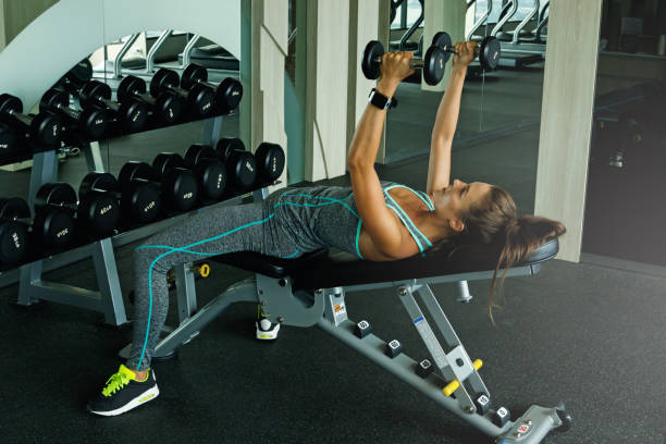 istock Woman working out with dumbbells in gym 1183587740