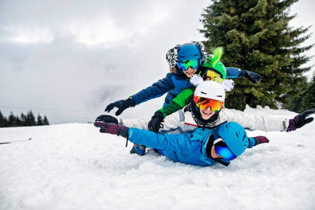 família de esqui que tem o divertimento no dia de inverno - skiing snow skiing helmet fun - fotografias e filmes do acervo