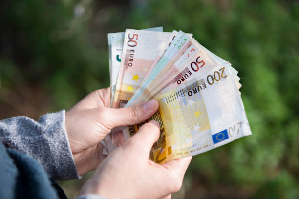 High angle view of unrecognizable young adult holding group of Euro banknotes High angle view of unrecognizable young adult holding group of Euro banknotes. Horizontal composition. minimum wage stock pictures, royalty-free photos & images