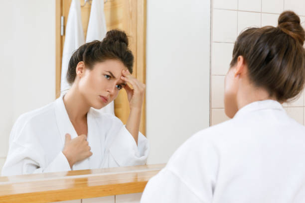 istock Woman with a headache looking into the mirror 1183599037