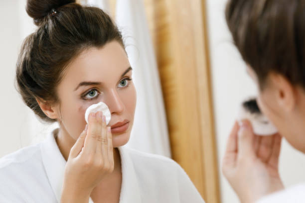 femme enlevant le maquillage avec un tampon de coton - démaquillant photos et images de collection