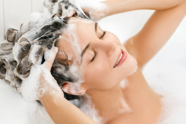 mujer se lava el pelo con champú - bathtub women naked human face fotografías e imágenes de stock