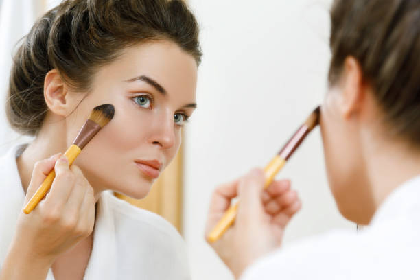 istock Woman applying foundation or blusher on her face 1183601633