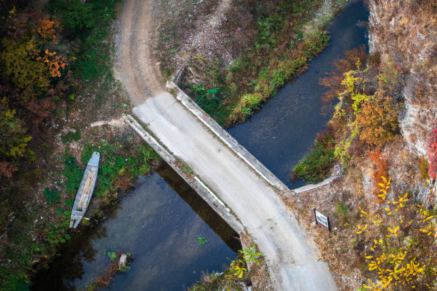 istock Small bridge on a river in canyon, ruined old boat by the bridge 1183605042