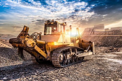 Heavy Equipment Bulldozer with Plow working at sunset
