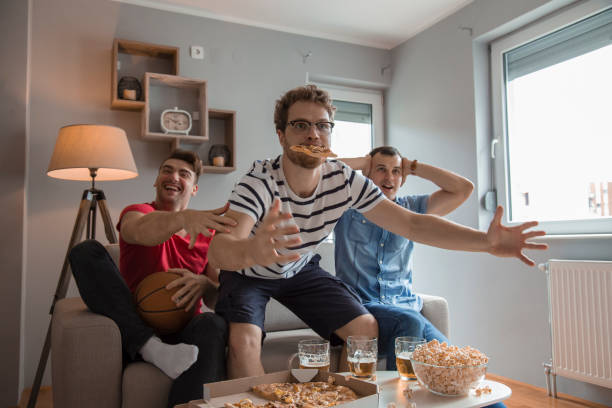 Group of friends watching basketball game and drinking beer stock photo