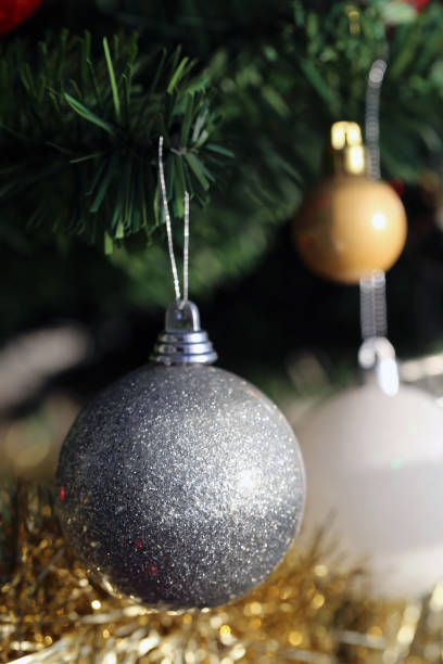 istock Shiny Christmas Ornaments Hanging from a Christmas Tree Branch 1183610656