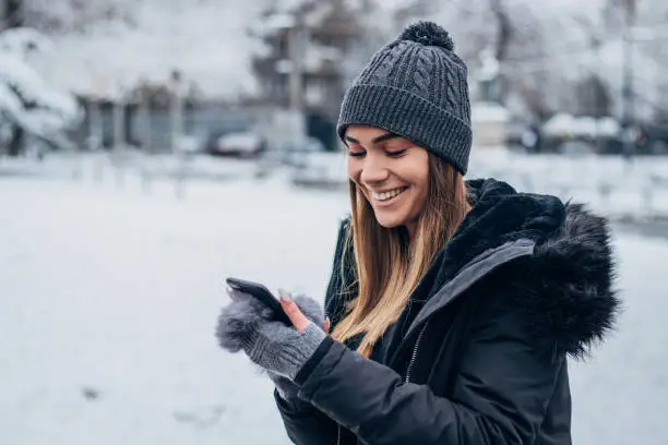 Photo of Cheerful young woman text messaging