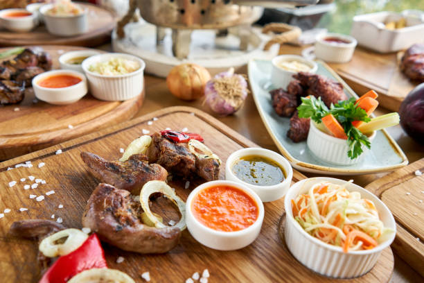 istock Lamb tongue kebab with Pickled cabbage and two sauces. Barbecue restaurant menu. Many different food on the table. Dinner party or Banquet 1183622565