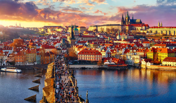 Panoramic view above at Charles Bridge Prague Panoramic view above at Charles Bridge Prague Castle and river Vltava Prague Czech Republic. Picturesque landscape with sunset old town houses with red tegular roofs and broach tower. charles bridge photos stock pictures, royalty-free photos & images