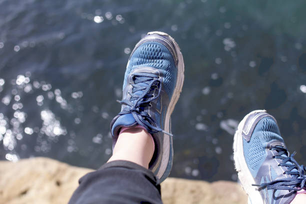 istock Shoes dangling above crystal blue water 1183623672
