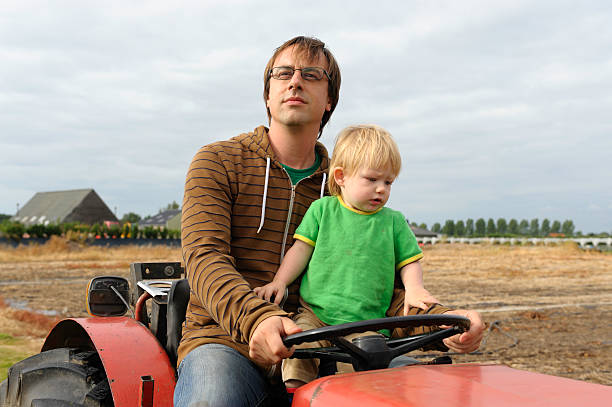 istock Father and son on a tractor 118362428