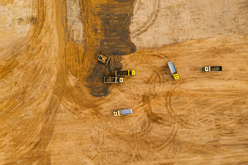 Top down and angled view of the sand pit mining industry construction.  Heavy industrial machinery, excavation site.