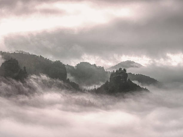 istock Cloudy hilly landscape. View over heavy cloud into rocky gulch 1183634357