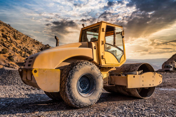 maszyna do zagęszczania rolkowego pracująca o zachodzie słońca - earth mover construction industrial equipment bulldozer zdjęcia i obrazy z banku zdjęć